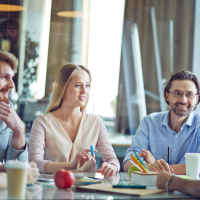 Vier Leute sitzen gemeinsam an einem Tisch und lernen Vier Leute sitzen gemeinsam an einem Tisch und lernen